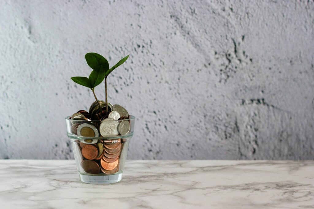 money in a glass with small tree growing